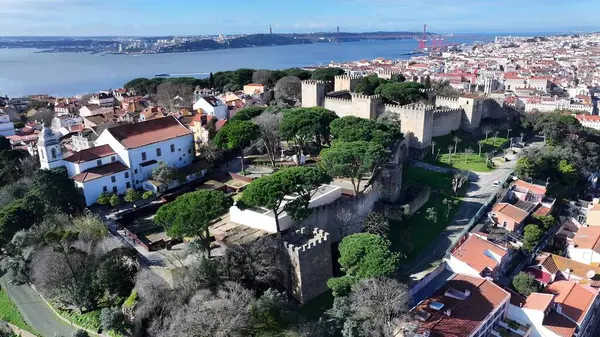 Lizbon 'daki Sao Jorge Kalesi. Yukardan bakıldığında hareketli bir şehirde ortaçağ binası. Şehir Gökyüzü Arkaplanı Kentsel. Şehrin yukarısında. Lizbon Portekiz.