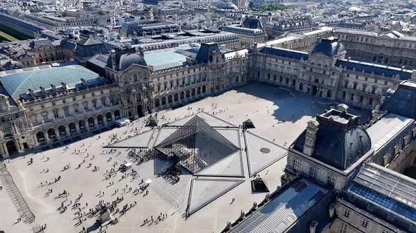 Paris 'teki Louvre Müzesi Ile De France. Gökdelen 'in havadan görünüşü ve şehir caddesinde yoğun trafik. Metropolitan Skyline Binaları Güzel. Bina Mimarlığı Şirketi.