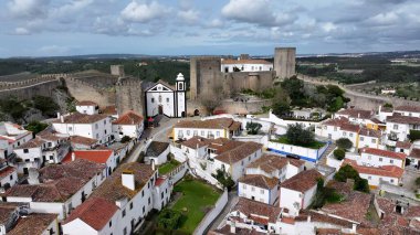 Leiria Portekiz 'in Obidos bölgesinde Obidos Skyline. Şehrin ünlü bölgesindeki ortaçağ binasının kuş bakışı görüntüsü. İş Bulutları Gökyüzü Şehir Merkezi. Arkaplan Panoramik Şehir.