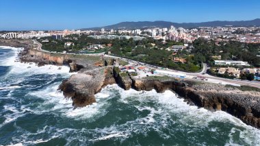 Lizbon 'un Cascais bölgesindeki Cascais Skyline. Yüksek binaları ve trafiği olan hareketli bir şehrin havadan görünüşü. Shore Sky Clouds Plaj Denizi. Uluslararası Plaj Panoraması.