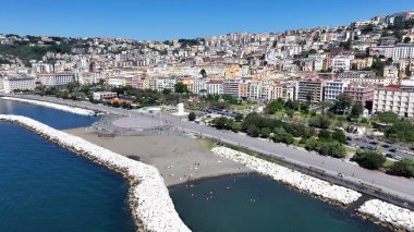 Napoli Campania İtalya 'daki Villa Comunale Parkı. Turkuaz Okyanus Dalgaları Tropik Sahile Yavaşça Çarpıyor. Şehir Gökyüzü Bulutları Şehir Arkaplanı. Şehir merkezinde geniş bir altyapı var. Napoli Campania.