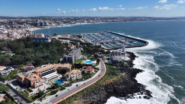 Lizbon 'un Cascais bölgesindeki Cascais Skyline. Turkuaz Okyanus Dalgaları Tropik Sahile Yavaşça Çarpıyor. Şehir Gökyüzü Arkaplanı Kentsel. Şehir merkezinin yukarısında..