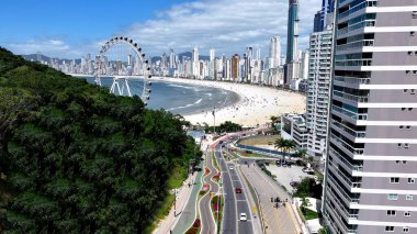 Camboriu Santa Catarina Brezilya 'daki plaj sahnesi. Yukarıdan görünüşlü çeşitli gezintileri olan Renkli Lunapark. Kıyı Bulutları Gökyüzü Sahil Denizi. Deniz kenarındaki panoramik. Camboriu Santa Catarina.