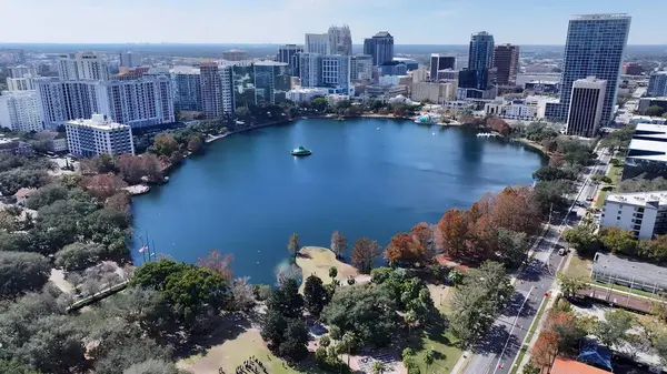 Orlando Skyline Orlando Florida Birleşik Devletleri 'nde. İnsansız hava aracı, etrafı gür ağaçlarla çevrili kaldırımlı bir bahçe yakalıyor. Metropolitan Manzara Gökdelenleri. Güzel. Metropolitan Şehir. Orlando Florida.