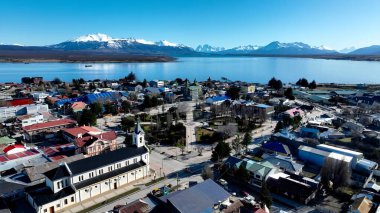 Puerto Natales 'teki Sahil Kasabası Antarktika Şili. Yüksek katlı binaların ve şehir yaşamını gösteren trafik gösterilerinin havadan görüntüsü. Açık hava Turizm İkonası Patagonya Buzulu. Karla Kaplanmış Hava.