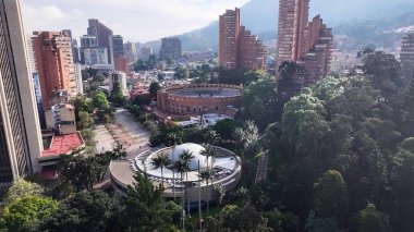 Bogota Bölge Başkenti Kolombiya 'daki Bicentenario Parkı. İnsansız hava aracı, etrafı gür ağaçlarla çevrili kaldırımlı bir bahçe yakalıyor. Altyapı Skyline Panoramik Şehir Görünümü Muhteşem.