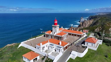 Lizbon 'un Sintra bölgesindeki Roca Burnu. Sahil şehrindeki hareketli bir deniz fenerinin havadan görünüşü. Sahil Bulutları Yaz mevsimi. Coast Outdoor Panning Wide 'da. Lizbon Sintra Bölgesi.