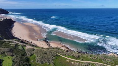 Lizbon 'un Sintra bölgesindeki Praia Grande Plajı. Kristal berrak sularla sersemletici sahilin havadan görünüşü. Horizon Sahili Denizi kıyısında. Shore Seaside Panning Wide 'da. Lizbon Sintra Bölgesi.