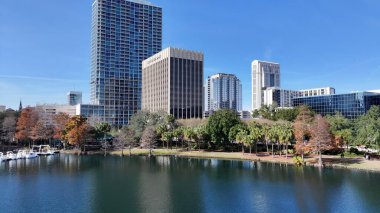 Orlando Florida 'daki Eola Parkı. Kuşlar, sokaklar ve binalarla çarpıcı şehir manzarasına bakıyor. Şehir merkezindeki İş Gökyüzü Arkaplanı. Şehir merkezindeki panoramik işleri. Orlando Florida.