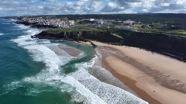 Lizbon 'un Sintra bölgesindeki Praia Grande Plajı. Turkuaz Okyanus Dalgaları Tropik Sahile Yavaşça Çarpıyor. Cennet Adası Manzarası Minnettar Güzel. Yaz Zamanı Minnettar Kıyı.