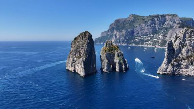Faraglioni İtalya 'da Capri Napoli' de Sallanıyor. Kristal berrak sularla sersemletici sahilin havadan görünüşü. Sahil Bulutları Yaz mevsimi. Sahil Panorama. Capri Napoli.
