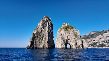 İtalya Capri Napoli 'deki Faraglioni Adası. Turkuaz Okyanus Dalgaları Tropik Sahile Yavaşça Çarpıyor. Terkedilmiş Peyzaj Eğlencesi Güzelliği. Terk edilmiş rıhtım kıyısı. Capri Napoli.
