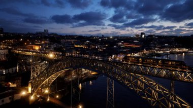Porto Portekiz 'de Sunset Dom Luis Köprüsü. Arka planda binaları olan şehir tren istasyonunun hava görüntüsü. Şehir Bulutları Yapısı Gökyüzü Aydınlanma Şehri. Kasaba Açık Hava. Porto Portekiz.