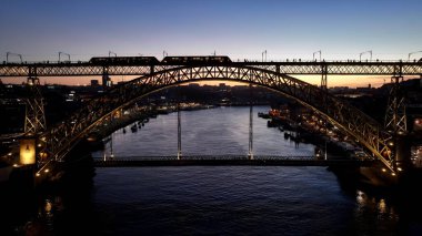 Porto Portekiz 'de Günbatımı I. Luis Köprüsü. Landmark Köprüsü 'nün Hava Görüntüsü Karmaşık Tasarımı Gösteriyor. İnşaat endüstrisi Skyline binaları meşgul. Endüstriyel Şehir Binaları. Porto Portekiz.