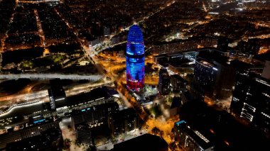 Barselona Katalonya 'daki Night Agbar Kulesi İspanya. İnanılmaz Skysraper 'lar ve caddedeki trafik yukarıdan izleniyor. Şehir Gökyüzü Binası Aydınlanmış Şehir. Aydınlatılmış Tarihi Yer. Barselona Katalonya.