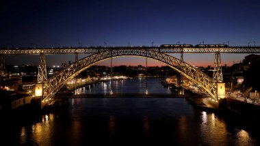 Porto Portekiz 'de Günbatımı I. Luis Köprüsü. Trafik, modern bir kablolu yayın konsolu köprüsünün karşısına geçiyor. Metropol Peyzaj Binaları Güzel. Metropole Urban 'da. Porto Portekiz.