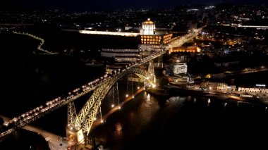 Porto Portekiz 'deki Gece Demir Köprüsü. Arka planda binaları olan şehir tren istasyonunun hava görüntüsü. Şehir Gökyüzü Binası Aydınlanmış Şehir. Aydınlatılmış Tarihi Yer. Porto Portekiz.