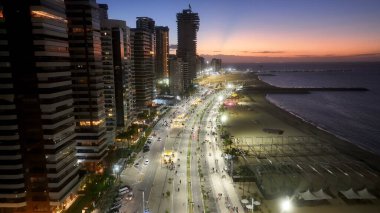 Ceara Brezilya 'daki Fortaleza' da Sunset Beira Mar Plajı. Günbatımı Şehri. Şehir merkezinde. Ceara Brezilya 'daki Fortaleza' da Beira Mar Plajı. Aydınlatılmış şehir manzarası. Drone Hava Görüntüsü.