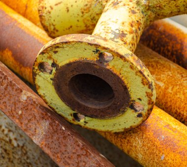 Geri dönüşüm için hurda metal. Eritme ve tekrar kullanım için bir sürü paslı endüstriyel ayrıntı. Eski paslı metal boru bağlantısı. Tasarım amacı için soyut arkaplan. Sıcak turuncu renk.