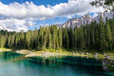 Güneşli bir günde biraz bulutla Carezza Gölü.