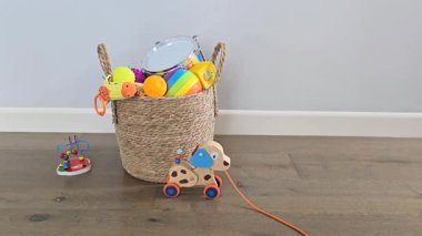 Ahşap bir köpek oyuncağı zeminde hareket ediyor ve çerçeveden kayboluyor. İnsansız minimalist bebek oyun sahnesi. Yumuşak doğal ışıklandırma, rahat ev atmosferi ve temiz bir arka plan..