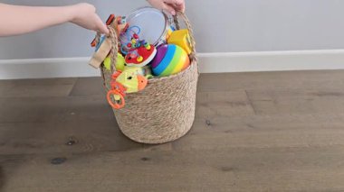 Elleri bebek oyuncaklarını açıyor ve ahşap köpeği ileri itiyor.