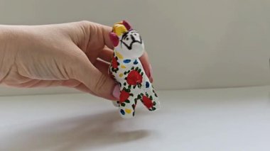 Beyaz arka planda Dymkovo Rus halk tarzında boyanmış geleneksel bir el yapımı kil at oyuncağı. Slav kültür mirasını ve Rus çömlek sanatını temsil eden eşsiz bir zanaatkar..
