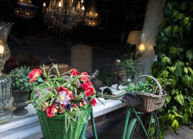 İngiltere 'de bir antikacının önünde çiçek sepetleri sergilenen eski bir eski model bisiklet..