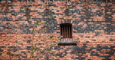 Viktorya döneminden kalma tuğla bir depoda paslı bir pencere..