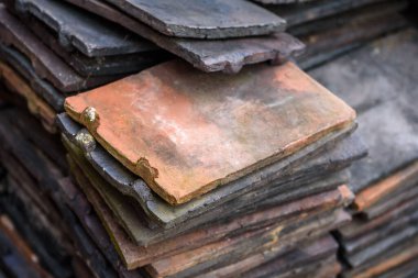 Bir yığın geri kazanılmış terracotta çatı kiremitleri.