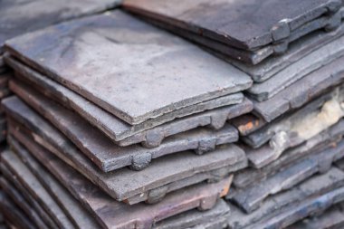 Bir yığın geri kazanılmış terracotta çatı kiremitleri.