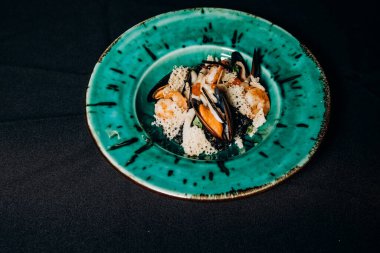 Mürekkep balıklı risotto, parmesan peynirli deniz ürünleri cipsi.