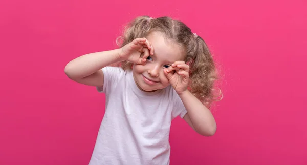 幸せな女の子あるショー眼鏡ジェスチャー上のピンクの背景 — ストック写真