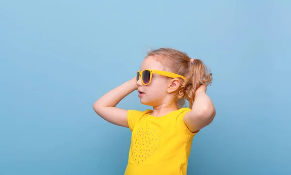 Klein Meisje Gele Zonnebril Een Blauwe Achtergrond — Stockfoto