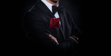 Siyah arka planda takım elbiseli zarif bir genç..