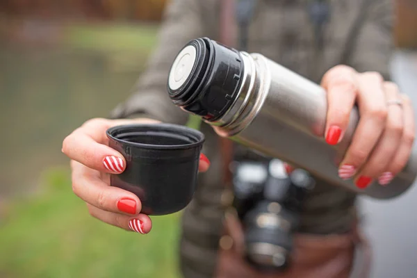 在寒冷季节 女人的手从热水瓶里倒茶或咖啡 — 图库照片