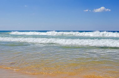 Deniz ve dalgalar mavi gökyüzüne karşı. Gün batımında güzel bir akşam gökyüzü ve deniz sörfü.