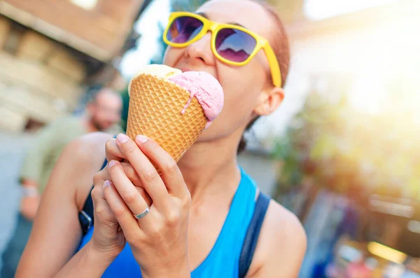 Attractive young woman with ice cream in a waffle cup in her hands.