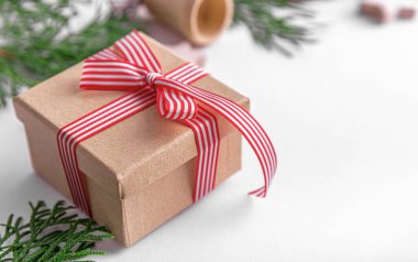 Kağıt hediye kutusu beyaz üzerine kırmızı şerit yay ile.