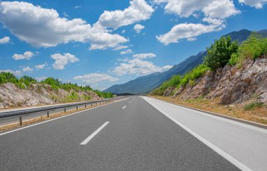 Empty long mountain road on a sunny summer day.