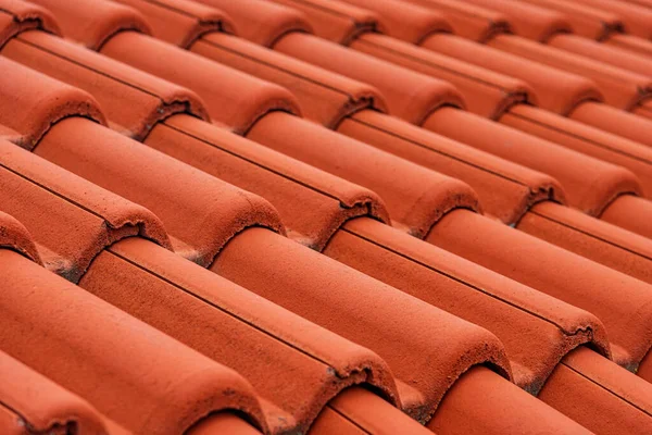 Red ceramic tiles on the roof of the house.