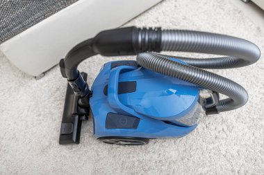 Modern vacuum cleaner in the living room. Vacuum cleaner on the background of the home interior.