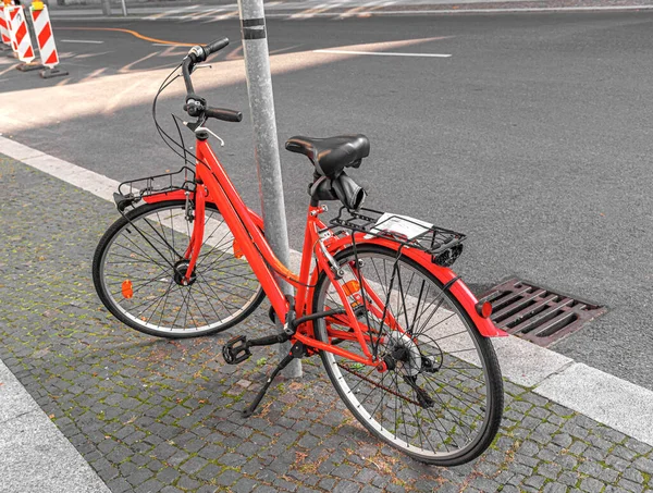 Una Bicicletta Rossa Parcheggiata Lampione Una Strada Della Città — Foto Stock