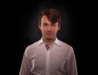 Karanlık bir arka planda genç bir adamın portresi.