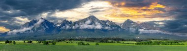 Tatra dağlarının panoramik görüntüsü. Baharda High Tatras 'ın manzarası. Karlı dağ tepeleri ve güzel gökyüzü.