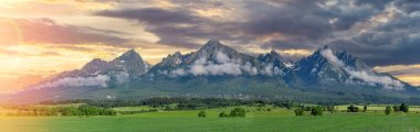 Tatra dağlarının panoramik görüntüsü. Baharda High Tatras 'ın manzarası. Karlı dağ tepeleri ve güzel gökyüzü.