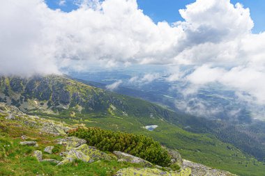 Dağ yamacındaki kayalar. Bulutların ve sislerin arasındaki dağ