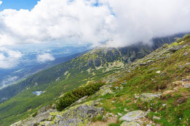 Dağ yamacındaki kayalar. Bulutların ve sislerin arasındaki dağ