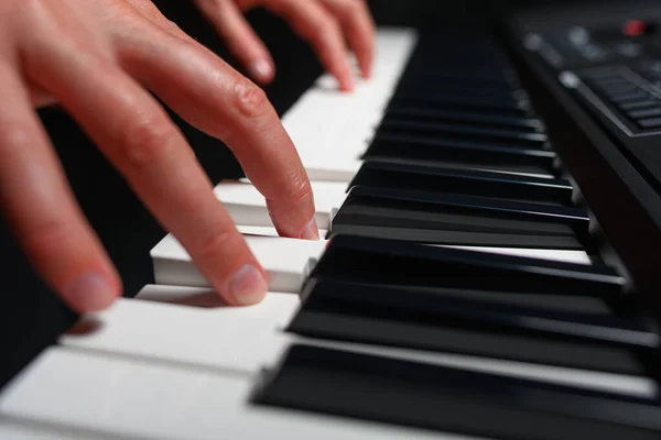 stock image Playing a synthesizer on a dark background. The musician plays the synthesizer.