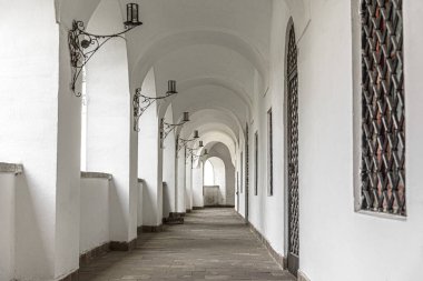 Pencereleri olan eski bir binanın uzun koridoru.